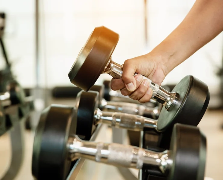 man holds a dumbbell