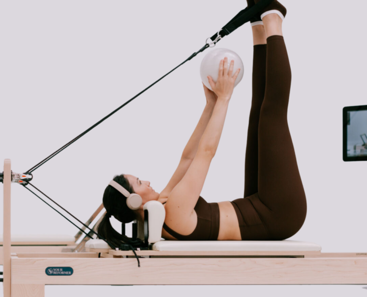 A woman using a Reformer.