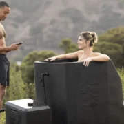 A woman in an Ice Barrel outdoors with a man.