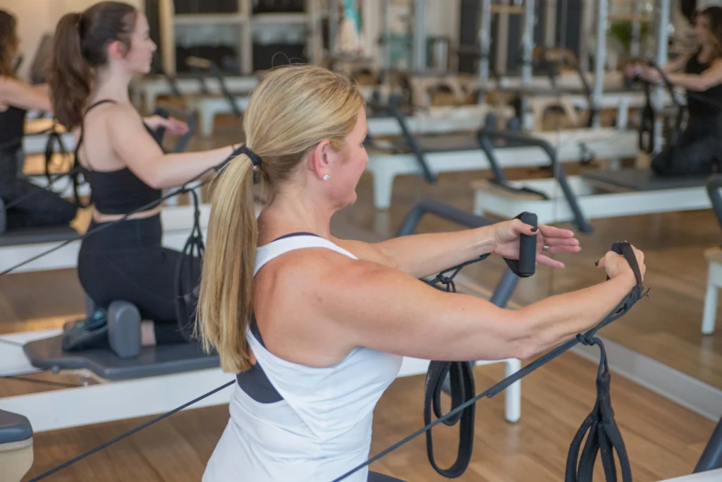 A woman in the middle of a BODYBAR Pilates class.