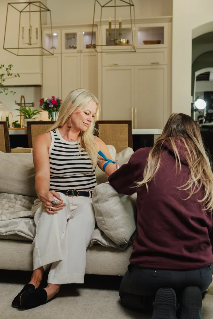 A woman getting her bloodwork done in her living room.