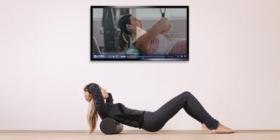 woman doing crunches while looking at TV screen
