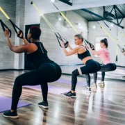 Women using suspension trainer at gym