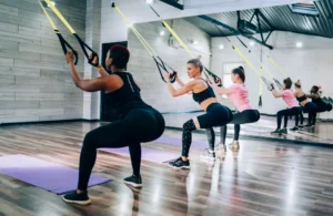 Women using suspension trainer at gym