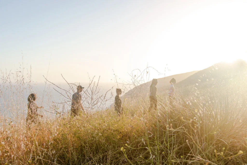 People hiking single file up a field.