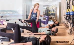 instructor helps a client at a Club Pilates