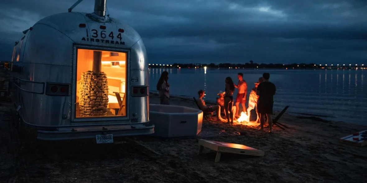 A group of people at the beach enjoying Swet's mobile sauna.