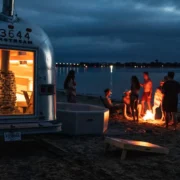 A group of people at the beach enjoying Swet's mobile sauna.