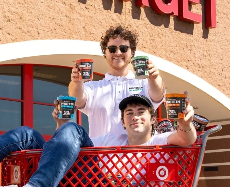 Protein Pints founders in a shopping cart outside of a Target store.