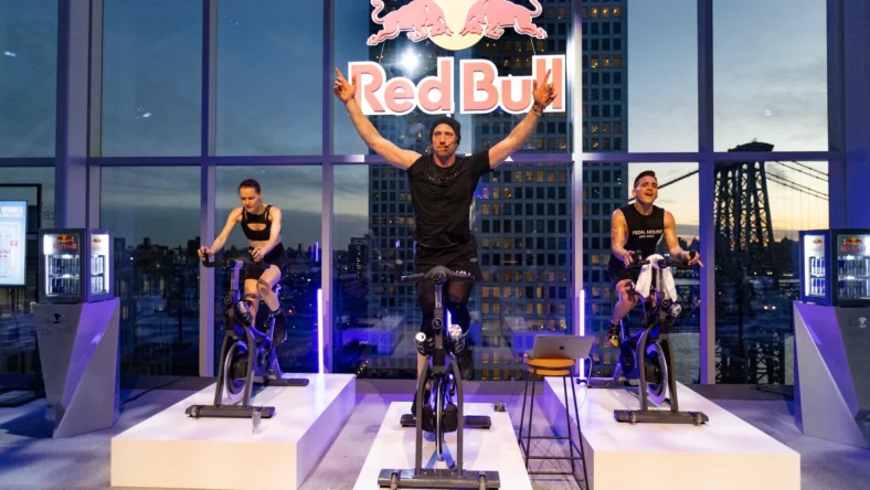 indoor cycling class inside a New York City studio adorned with a Red Bull logo
