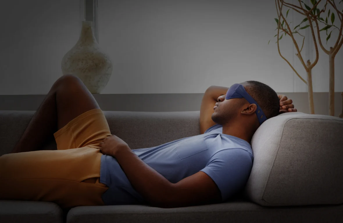 Man sleeping on couch wearing mask