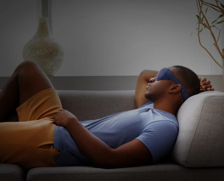 Man sleeping on couch wearing mask