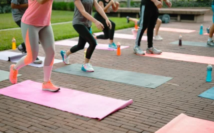 A group fitness class with people on yoga mats.