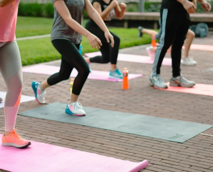 A group fitness class with people on yoga mats.