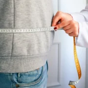 A doctor measuring a patient's waist.