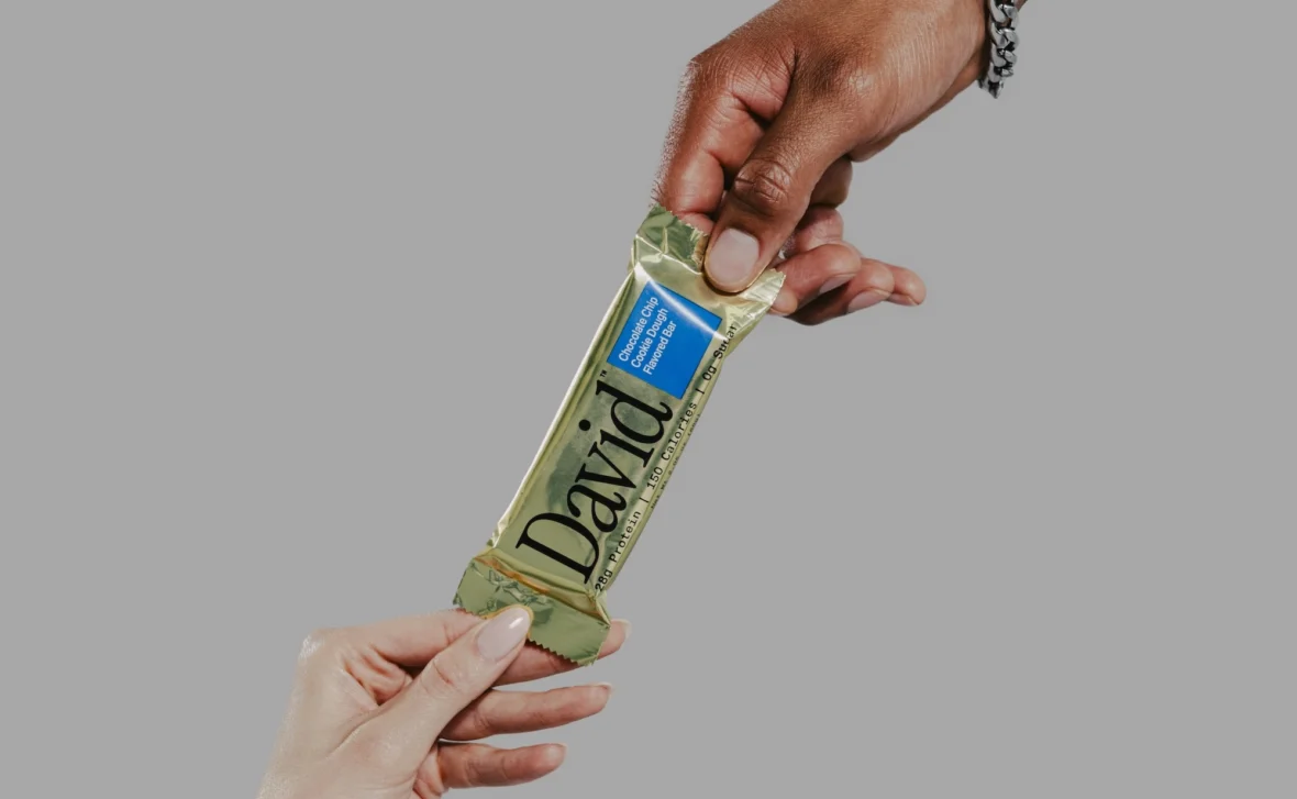hands of a man and woman grab a David protein bar