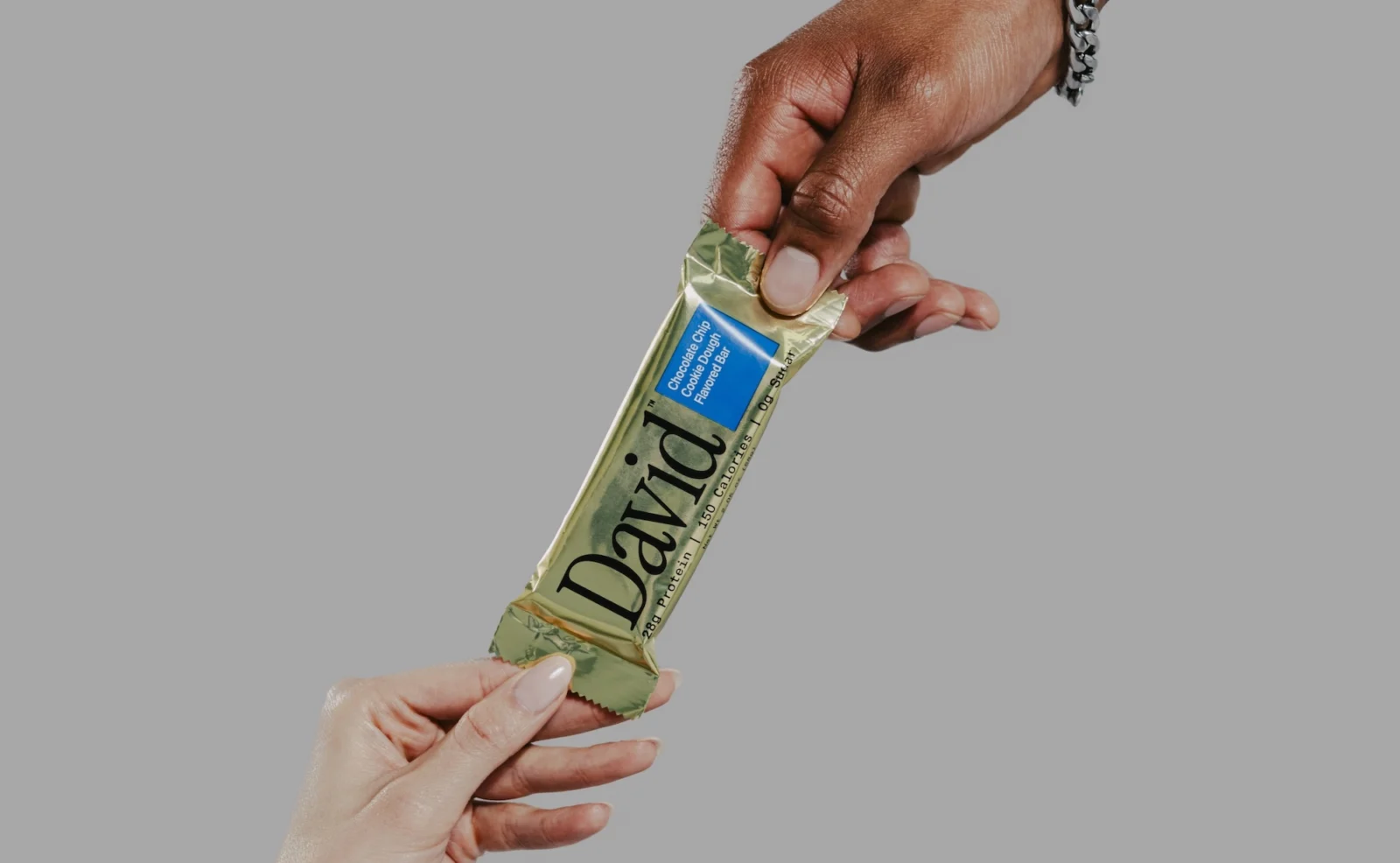 hands of a man and woman grab a David protein bar