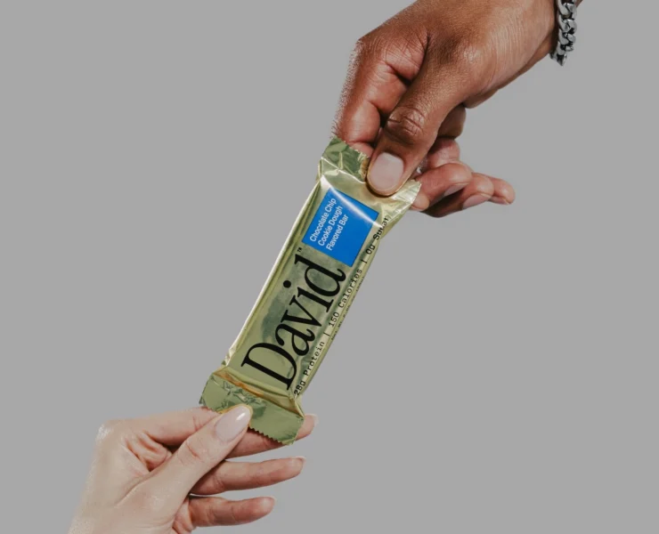 hands of a man and woman grab a David protein bar