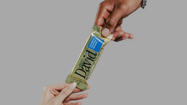 hands of a man and woman grab a David protein bar