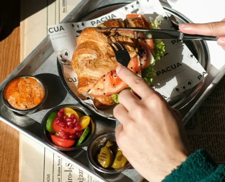 a person cutting into a croissant