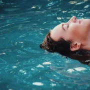 a woman relaxing/floating in an indoor pool