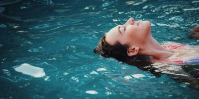 a woman relaxing/floating in an indoor pool