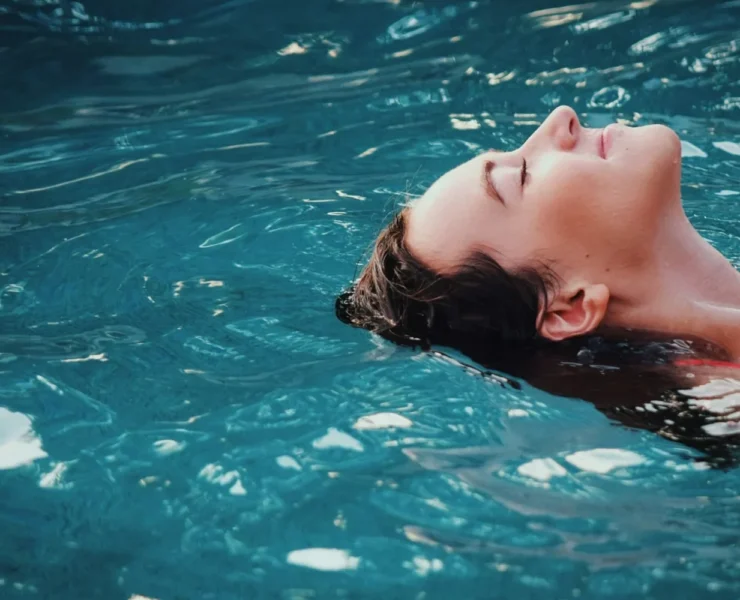 a woman relaxing/floating in an indoor pool