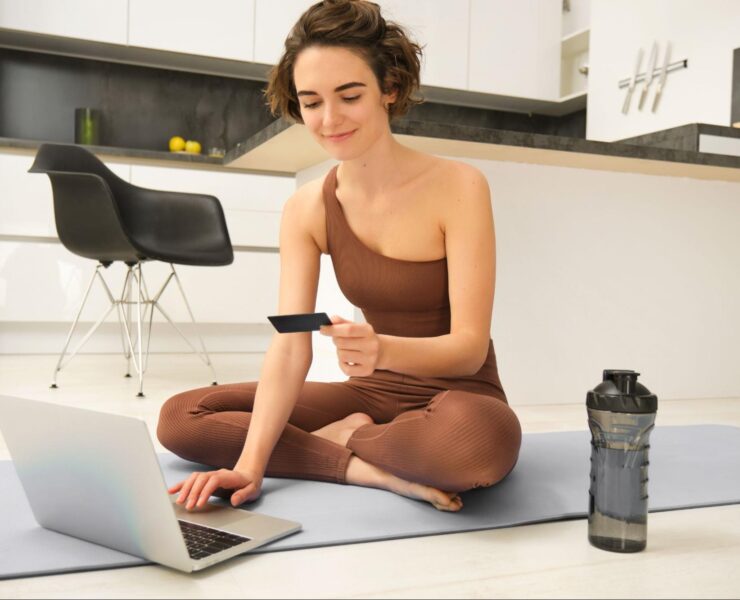 Woman using ecommerce on yoga mat