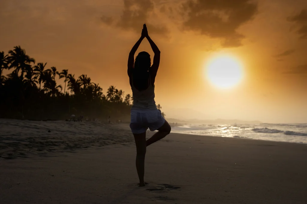 woman doing yoga at the beach