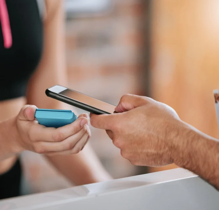 man scans his phone to enter the gym