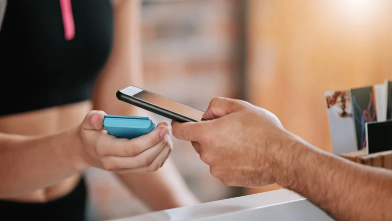 man scans his phone to enter the gym