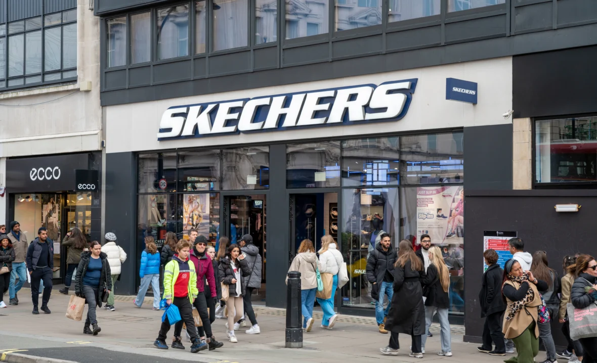 The exterior of a Skechers store with people milling about outside and in front of the store.