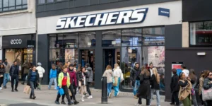 The exterior of a Skechers store with people milling about outside and in front of the store.