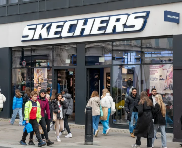 The exterior of a Skechers store with people milling about outside and in front of the store.
