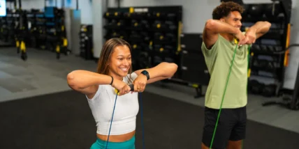 A man and woman using TRX.