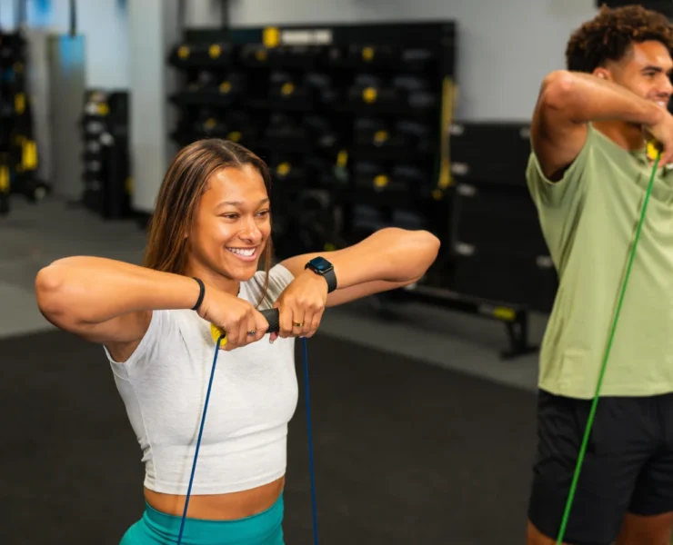 A man and woman using TRX.
