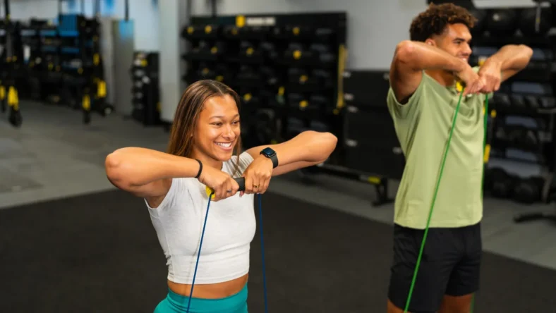 A man and woman using TRX.