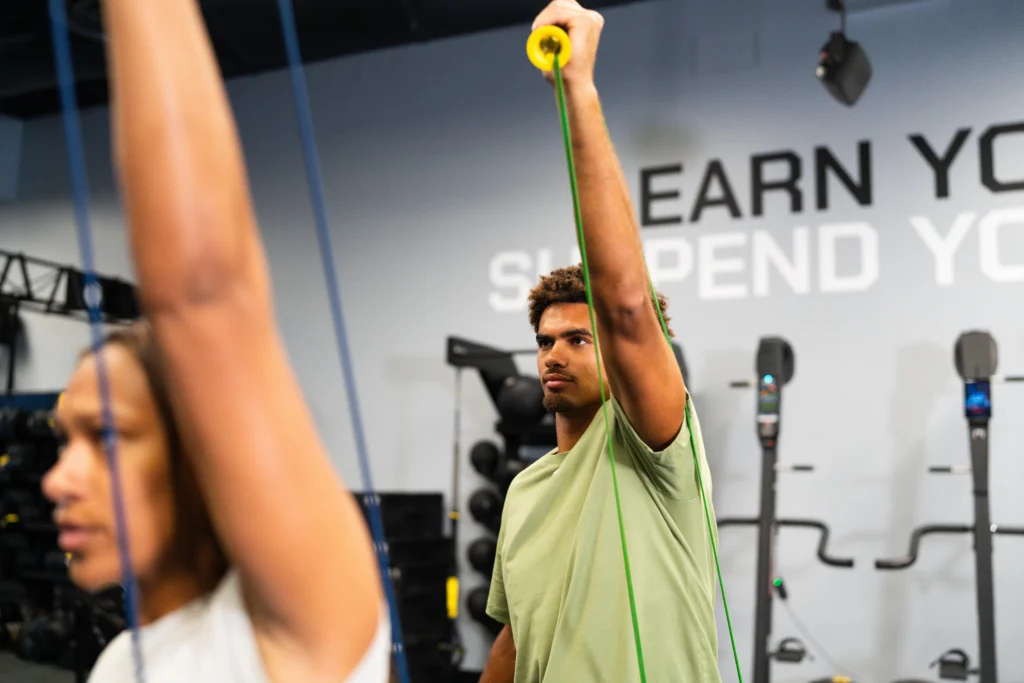 A man and woman using TRX.