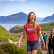 A group of people hiking in a picturesque area with hills in the background.