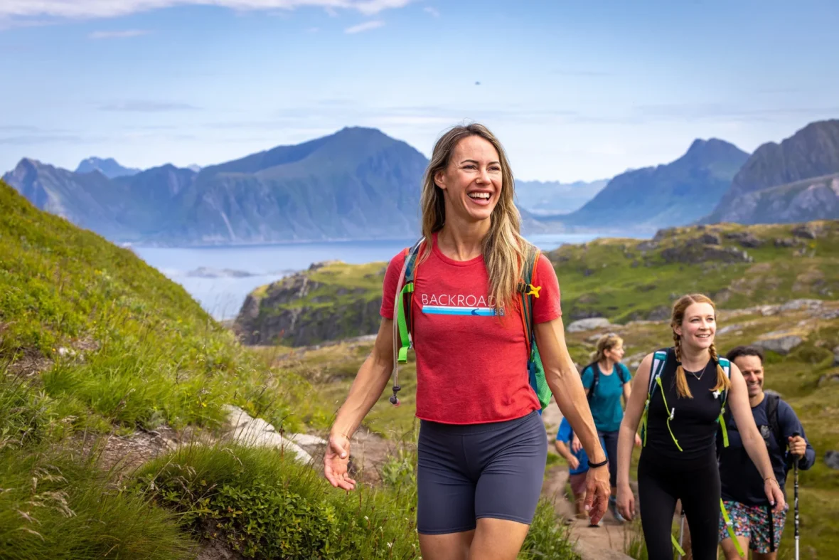 A group of people hiking in a picturesque area with hills in the background.