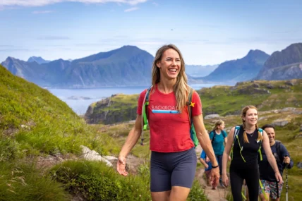 A group of people hiking in a picturesque area with hills in the background.