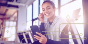 woman listening to earbuds while holding phone