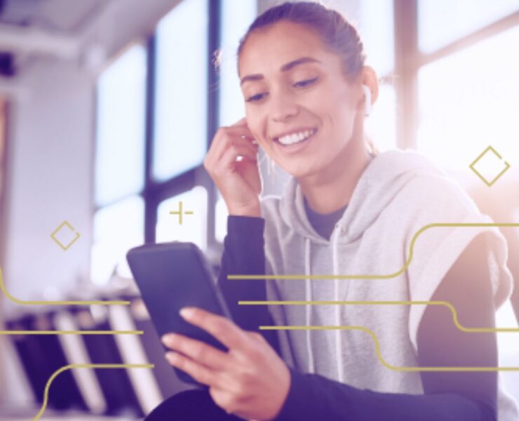 woman listening to earbuds while holding phone