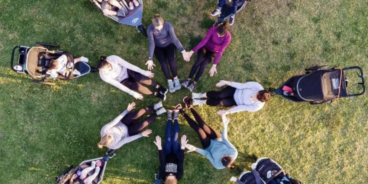 A group of women in a circle with strollers and babies.