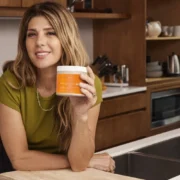 Marisa Tomei holding a jar of Terra Mare in a kitchen.