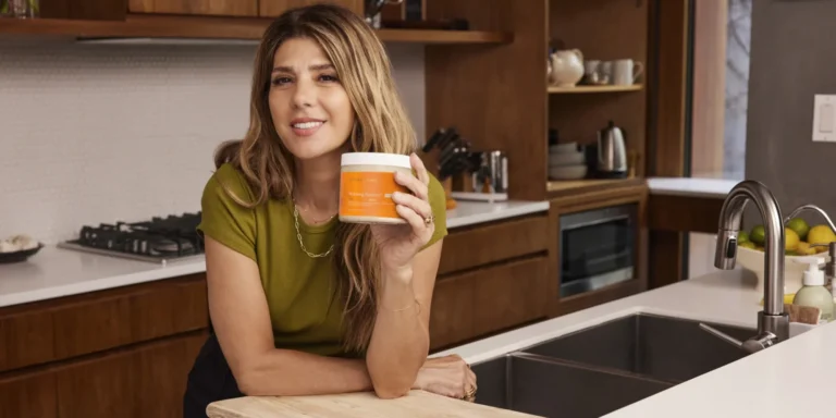 Marisa Tomei holding a jar of Terra Mare in a kitchen.
