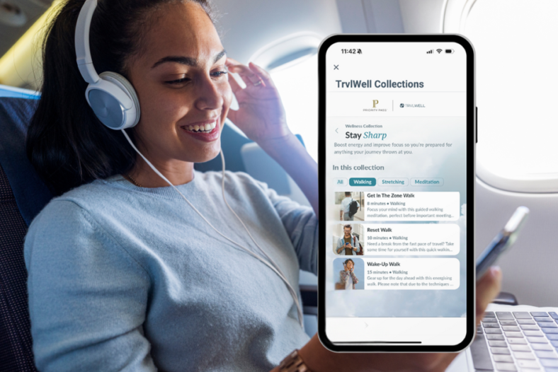 A woman on a plan looking at her phone and wearing headphones.