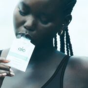 model eating Alo Daily Greens shot