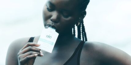 model eating Alo Daily Greens shot