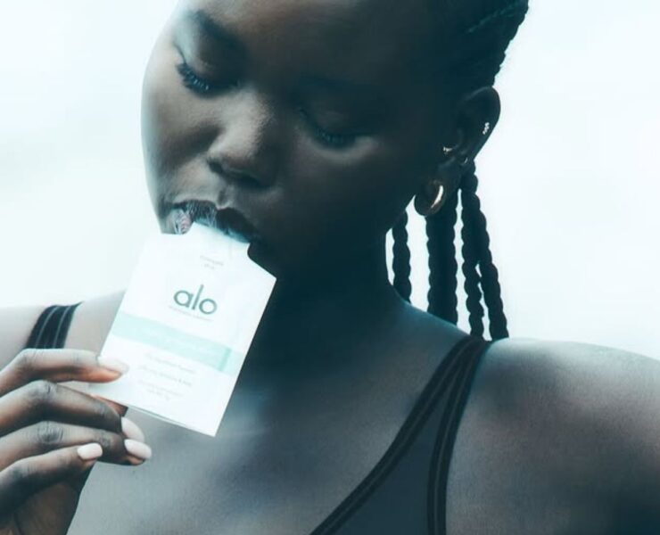 model eating Alo Daily Greens shot